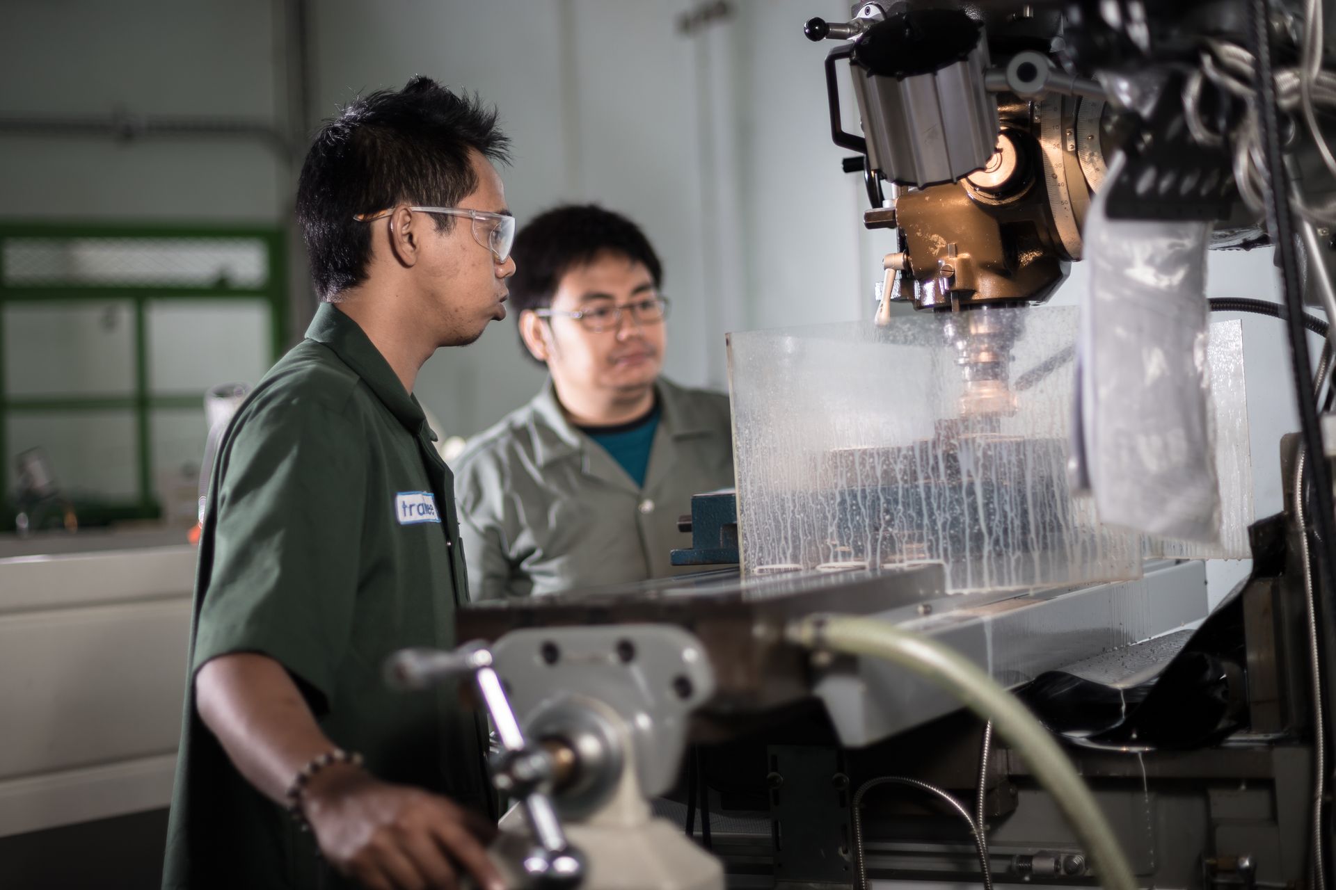 Two technicians operating a CNC machine in a workshop
