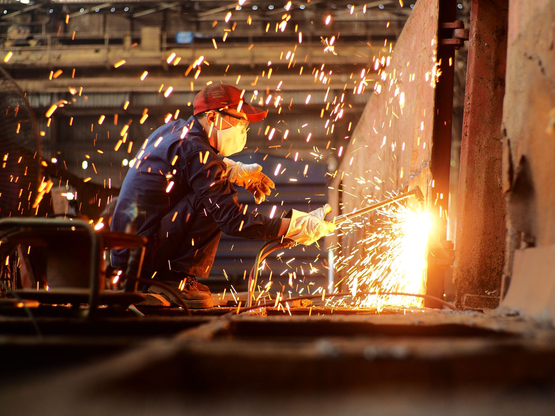 Welder working in a factory as sparks fly