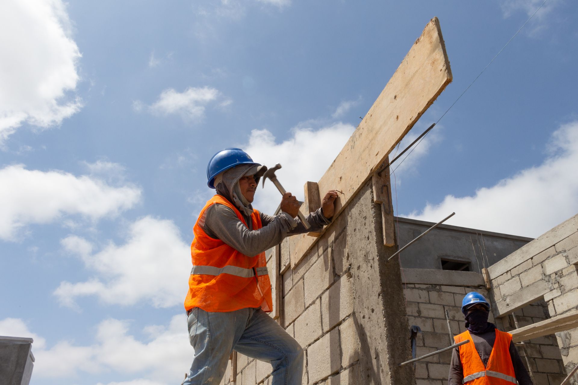 Construction workers building a structure under a clear sky