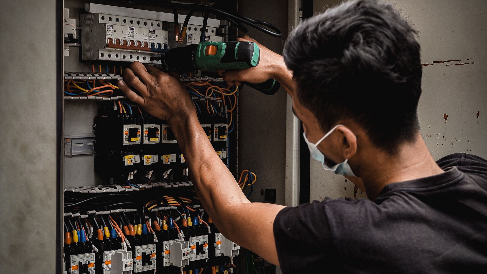 Electrician working on an industrial circuit breaker panel