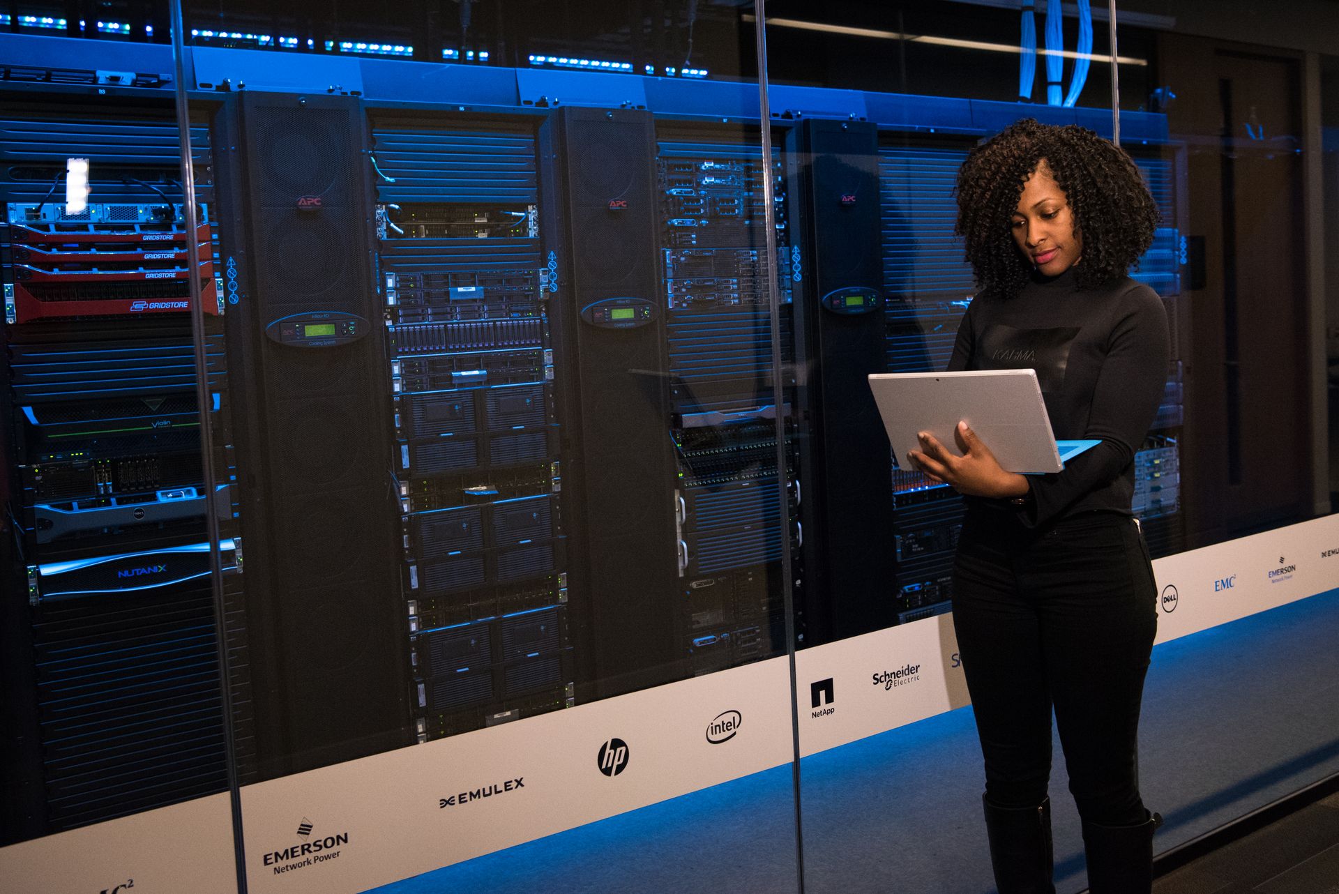 Engineer with a laptop monitoring servers in a modern server room
