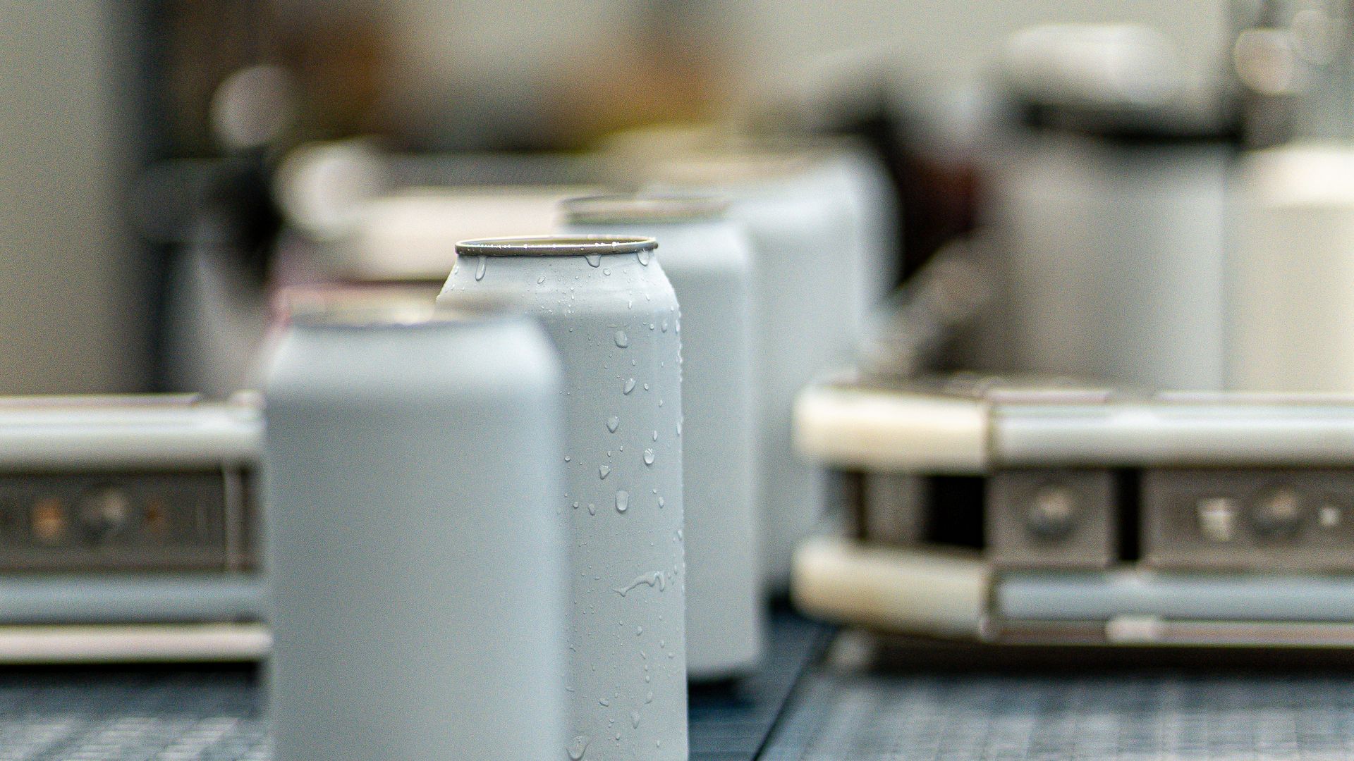Aluminum cans moving along a conveyor belt in a food plant
